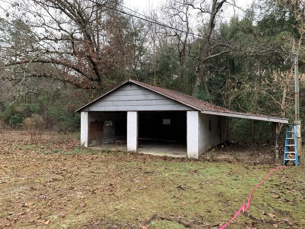 Garage and Lean-To Shed Before Demolition Two-car garage with attached open lean-to shed before demolition