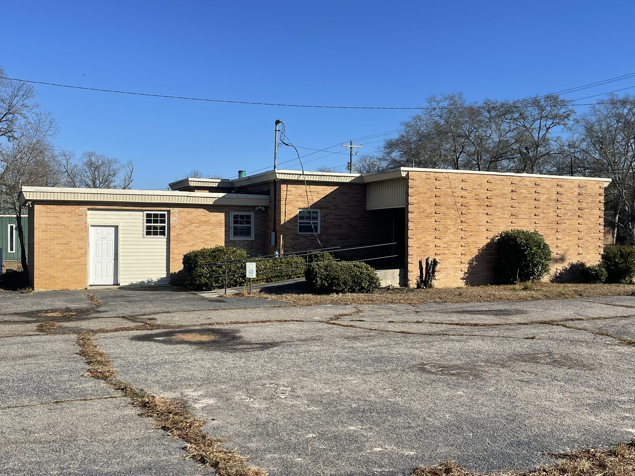 Before building demolition in Denmark SC showing rear access ramp paved lot and brick commercial building