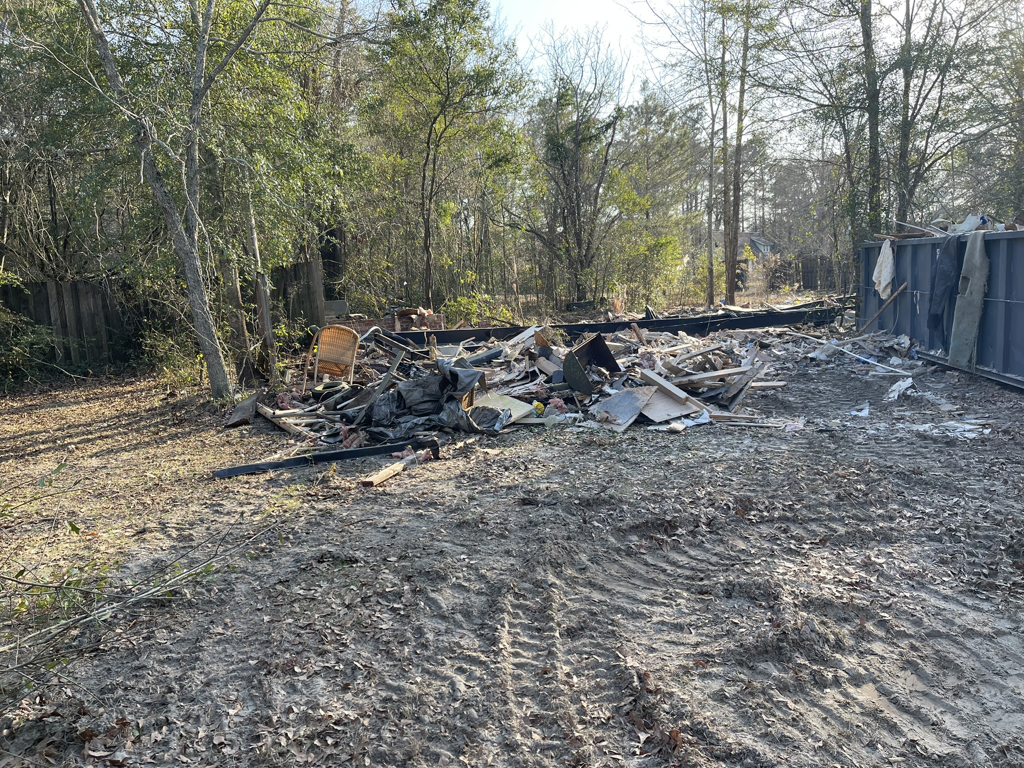 Mobile home demolition cleanup in progress on a wooded New Ellenton property